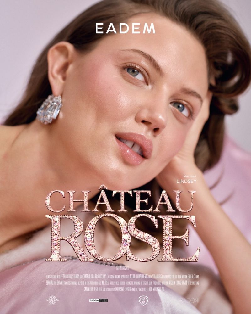 Glamorous portrait of a model with glowing skin and statement earrings, gazing at the camera against a soft pink background. EADEM logo visible.