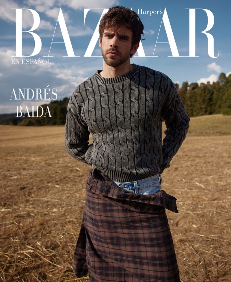 Andrés Baida is featured on a Harper's Bazaar cover. The portrait shot shows him in a gray sweater, standing in a field with trees in the background.