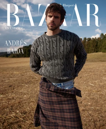 Andrés Baida is featured on a Harper's Bazaar cover. The portrait shot shows him in a gray sweater, standing in a field with trees in the background.