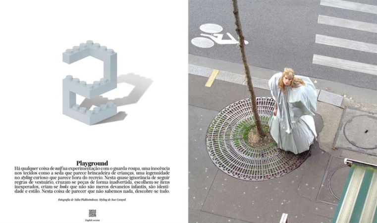 Fashion editorial shot from above shows a model in a voluminous dress standing near a tree on a city sidewalk. A toy brick is nearby.