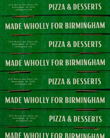Stack of green pizza boxes with white text showcasing a promotional message and the words Pizza & Desserts, presenting a culinary offering.