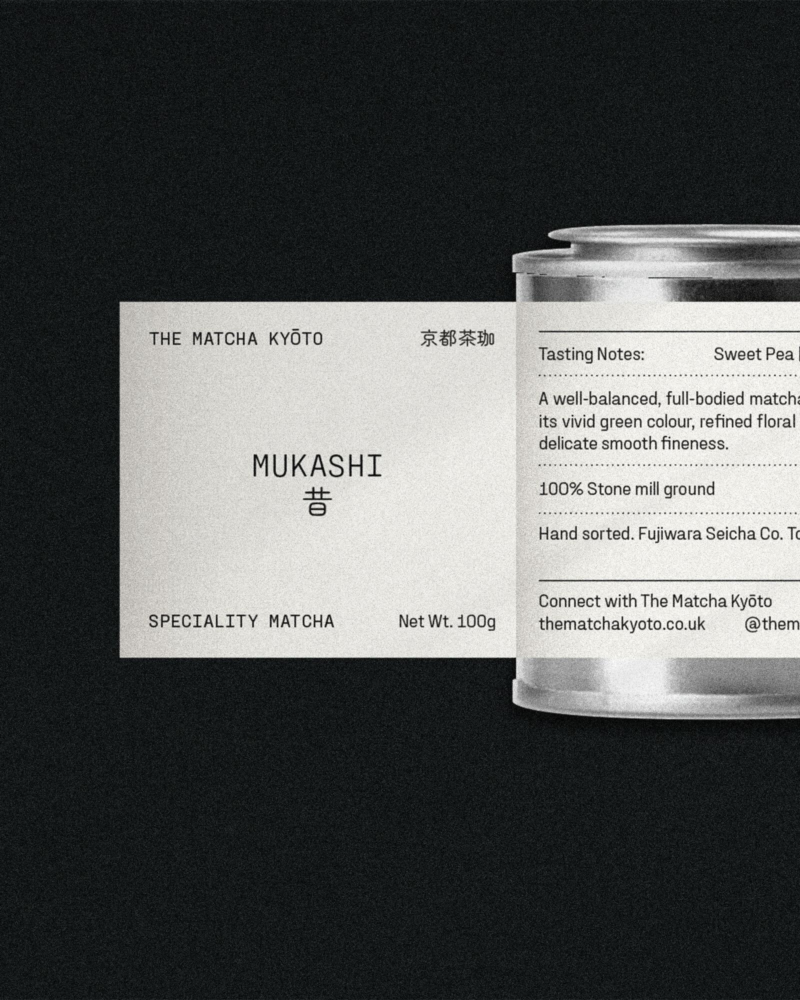 The Matcha Kyoto's Mukashi matcha product with its packaging featuring a label and a silver tin container, presented on a dark backdrop.