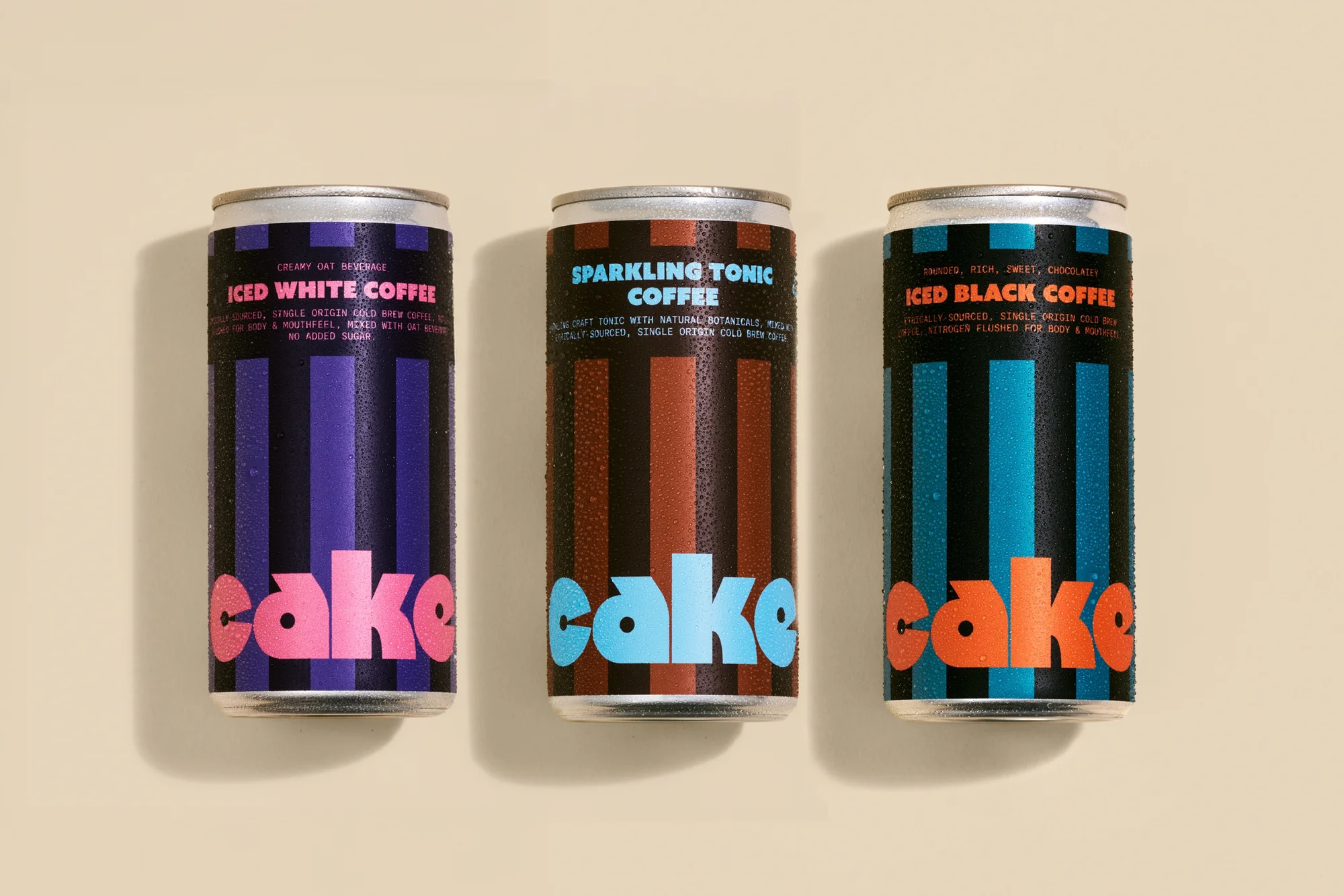 Three Cake brand canned coffees: Iced White Coffee with creamy oat beverage, Sparkling Tonic Coffee with natural botanicals, and Iced Black Coffee.