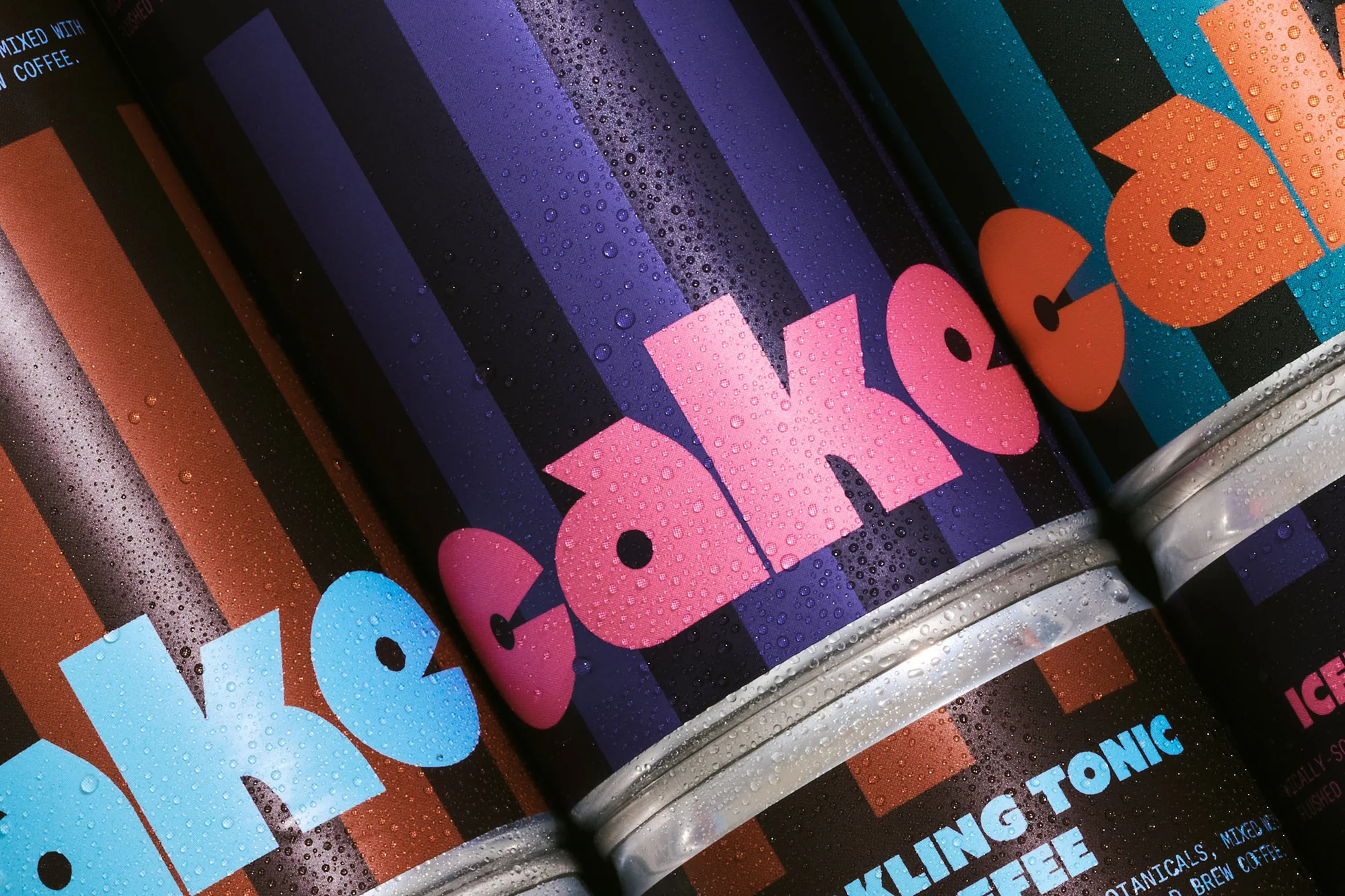 Close-up of colorful beverage cans with water droplets and bold sans-serif typography on striped backgrounds; stacked for a refreshing aesthetic.