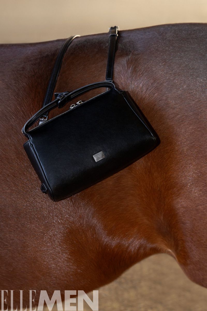 Black leather handbag resting on a brown horse coat for Elle Men China editorial project The Horse in Dream