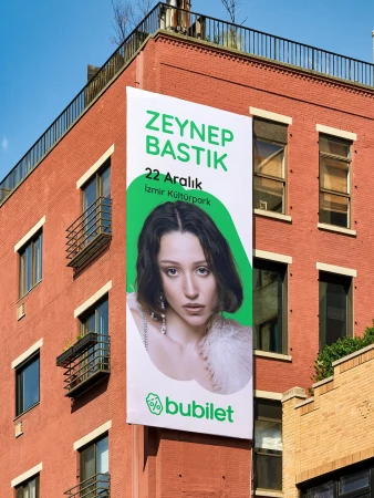 Building advertisement featuring Zeynep Bastik in white and green with the 'bubulet' logo, promoting a concert on a red brick building.