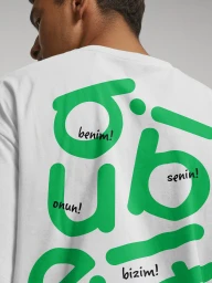 Man wearing a white t-shirt featuring large green typographic graphics and handwritten text on the back