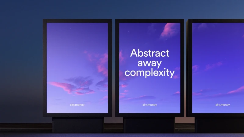 Three digital billboards display a gradient purple sky with faint clouds and the text, 'Abstract away complexity' and 'sky.money.'