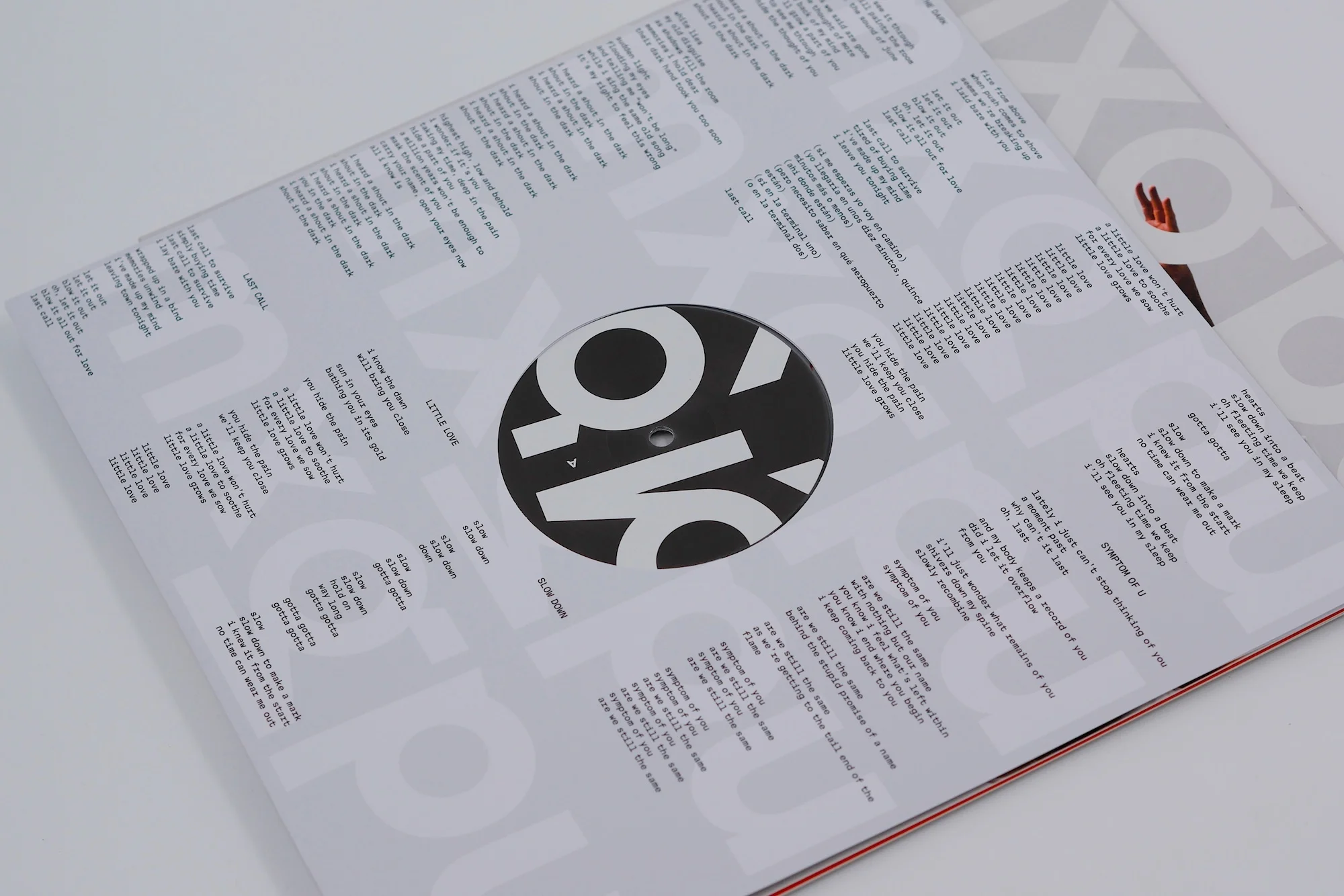 Close-up of a vinyl record cover with song lyrics and a minimalist design, featuring bold typography and a clean, modern aesthetic.