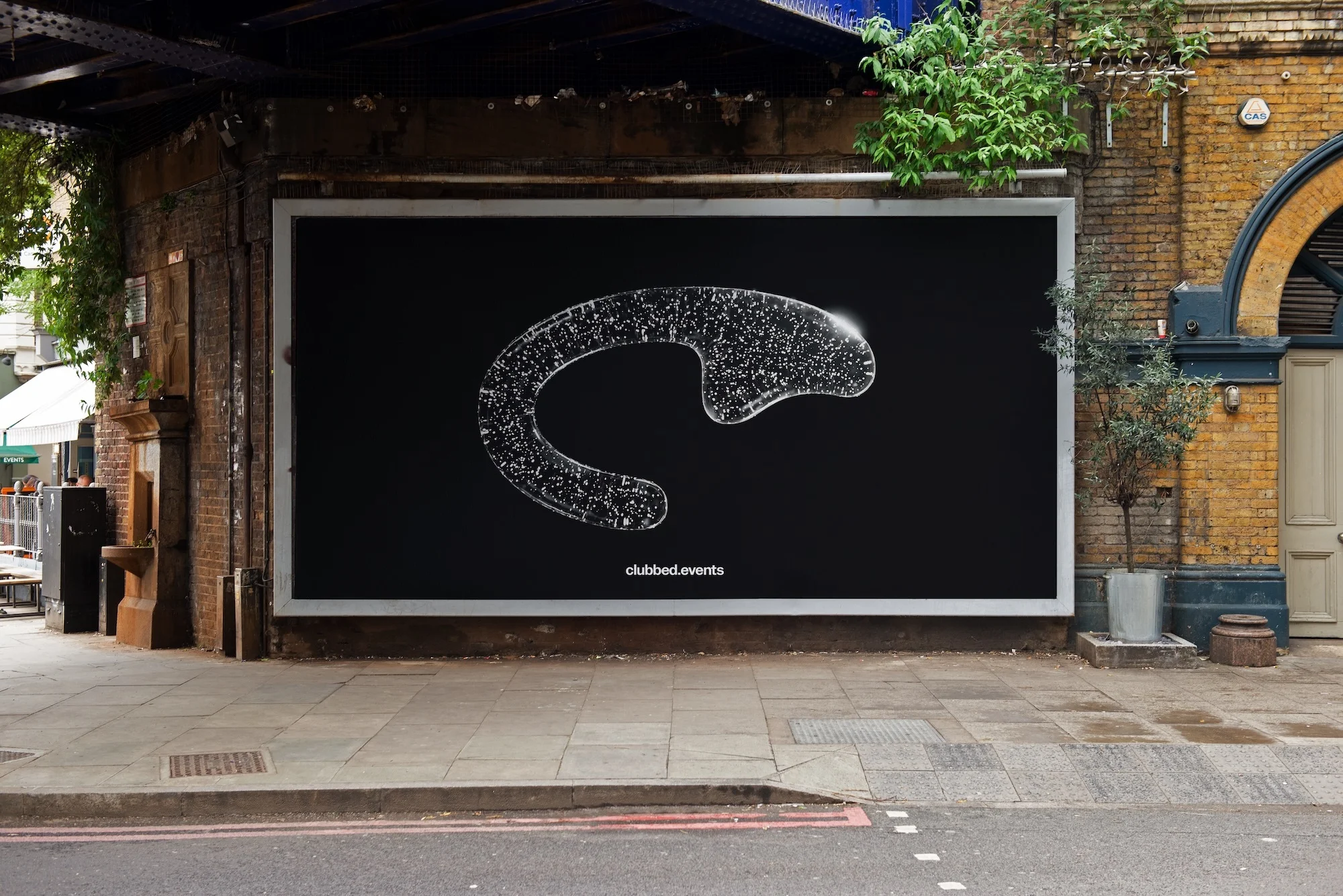 Outdoor advertisement featuring an abstract glowing 'C' shape on a black background, promoting clubbed.events, affixed to a brick building.