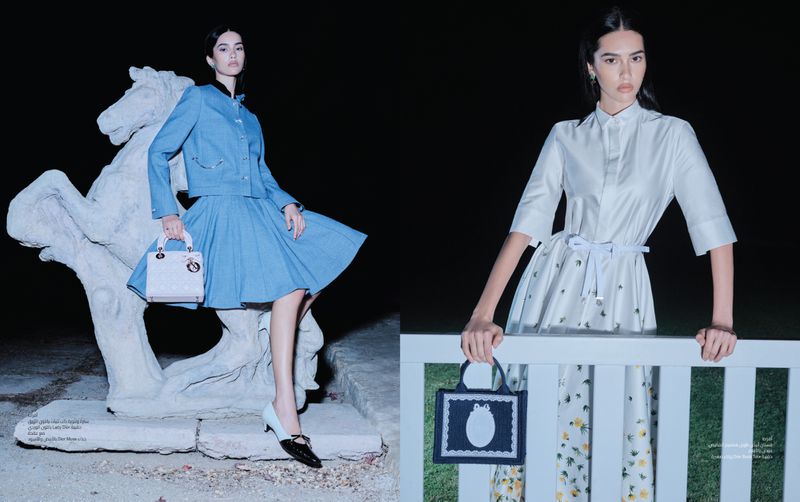 Two women pose with designer handbags in a dark outdoor fashion editorial. One woman poses with a horse statue; the other, with a fence.