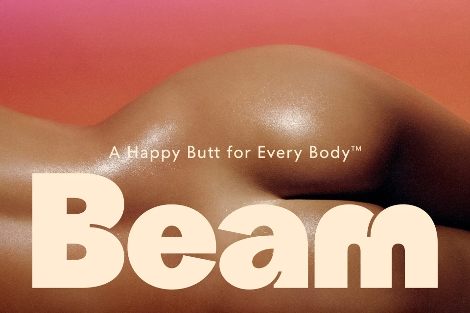 Woman's back and buttocks against a gradient peach and pink background. 'Beam' in cream text is displayed in the foreground.