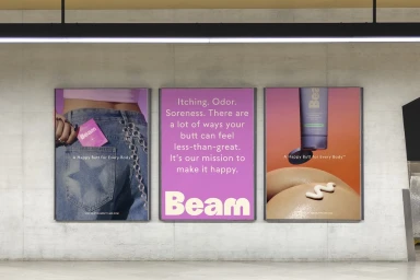 Three illuminated advertising posters for Beam displayed on a concrete wall in a public transit station.