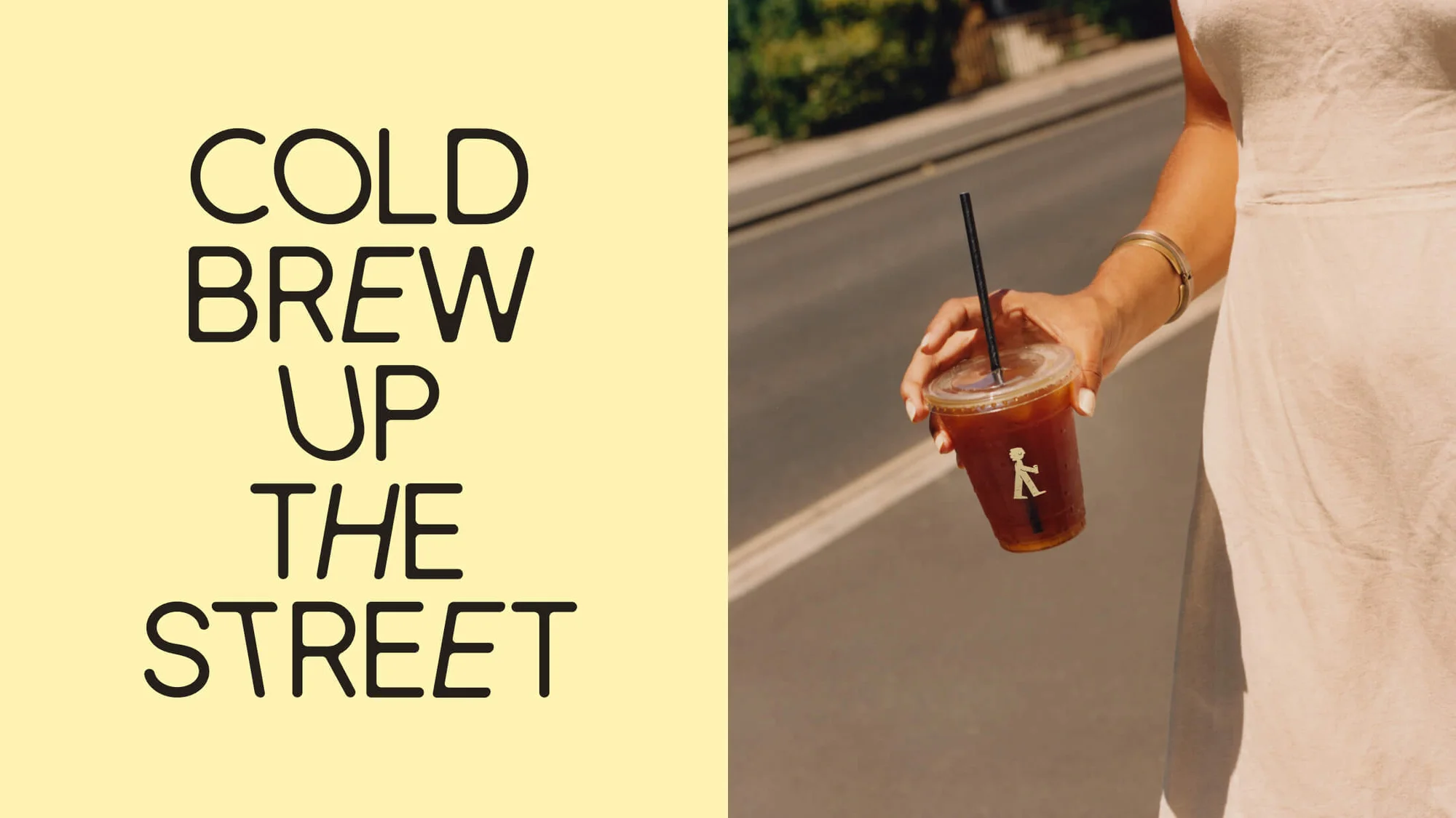 Woman holds a cold brew coffee on a street with text overlay on left in yellow background. Outdoor shot with natural light.