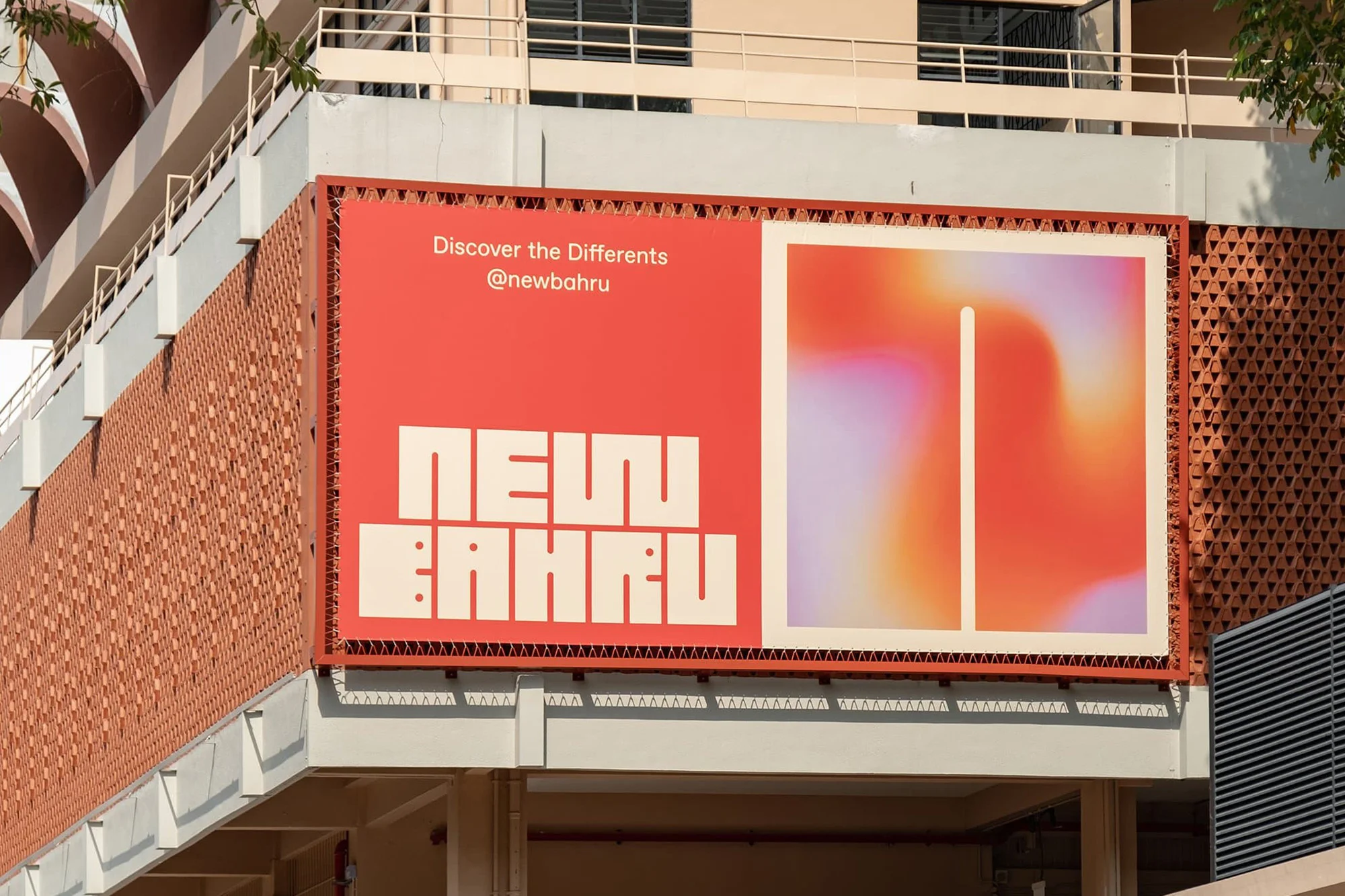 A modern advertising billboard for New Bahru displays a text logo and abstract design, mounted on a building with patterned brickwork.