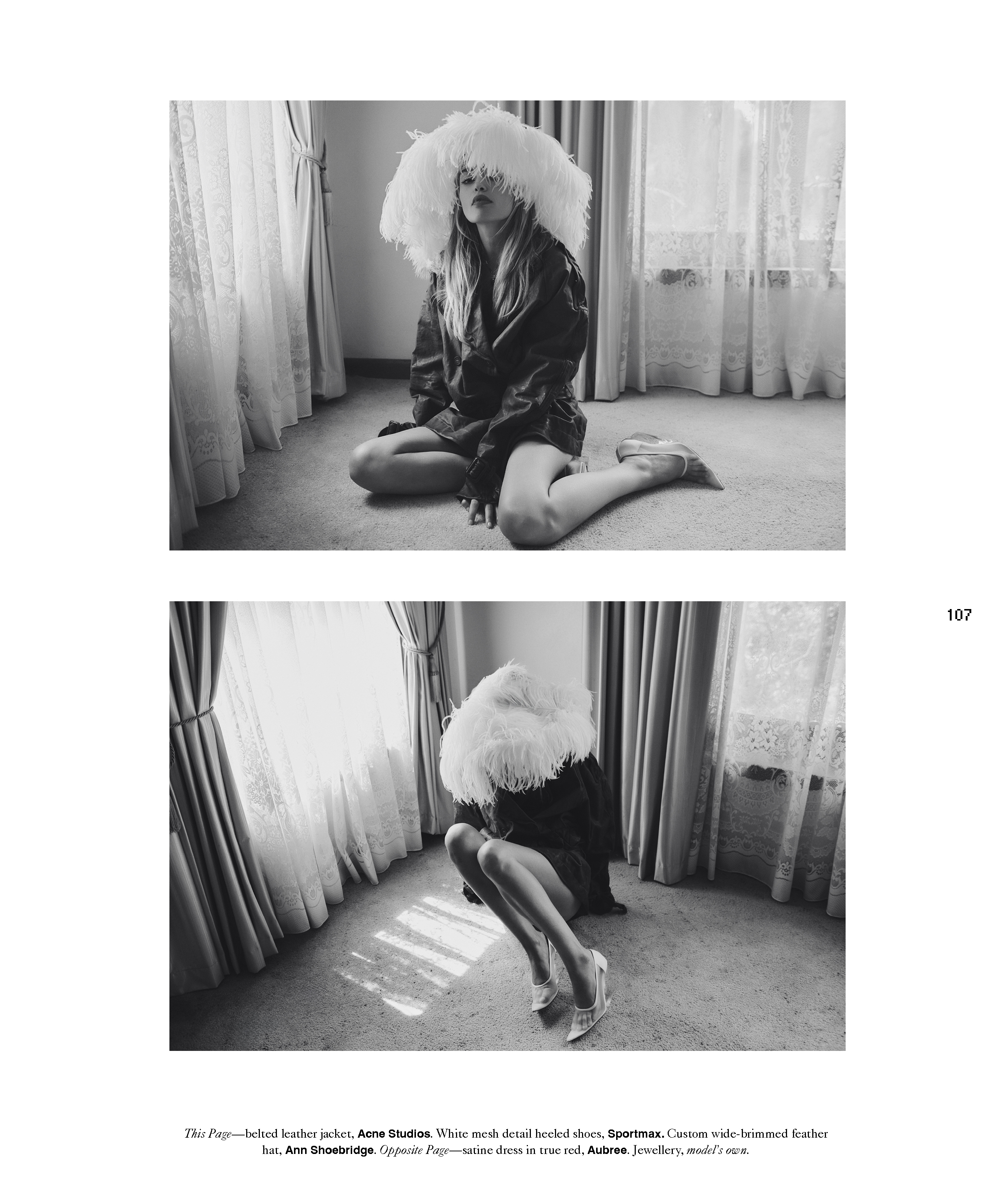 Black and white fashion shot of woman sitting on floor wearing a large feathered hat, jacket, and shoes, with a window behind her.