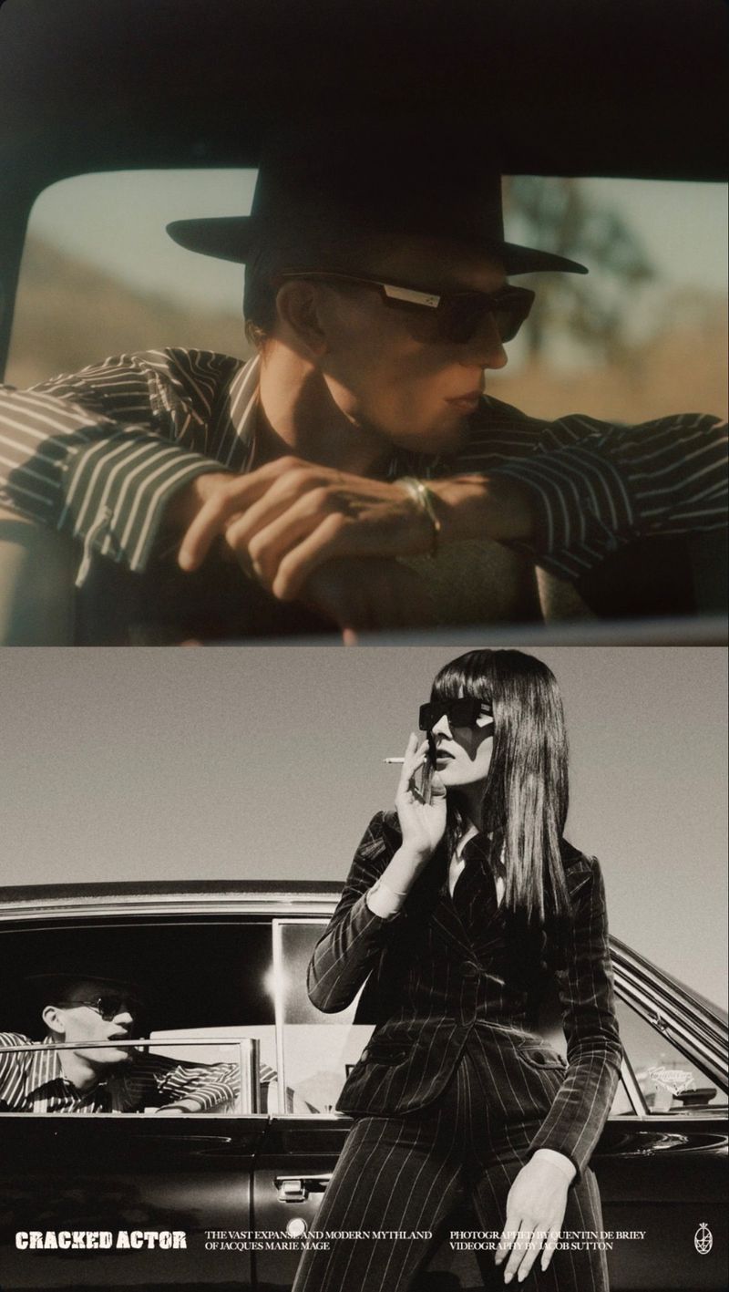 Fashion editorial shot featuring a man in a striped shirt and hat inside a car, with a woman in a pinstripe suit leaning on the car.