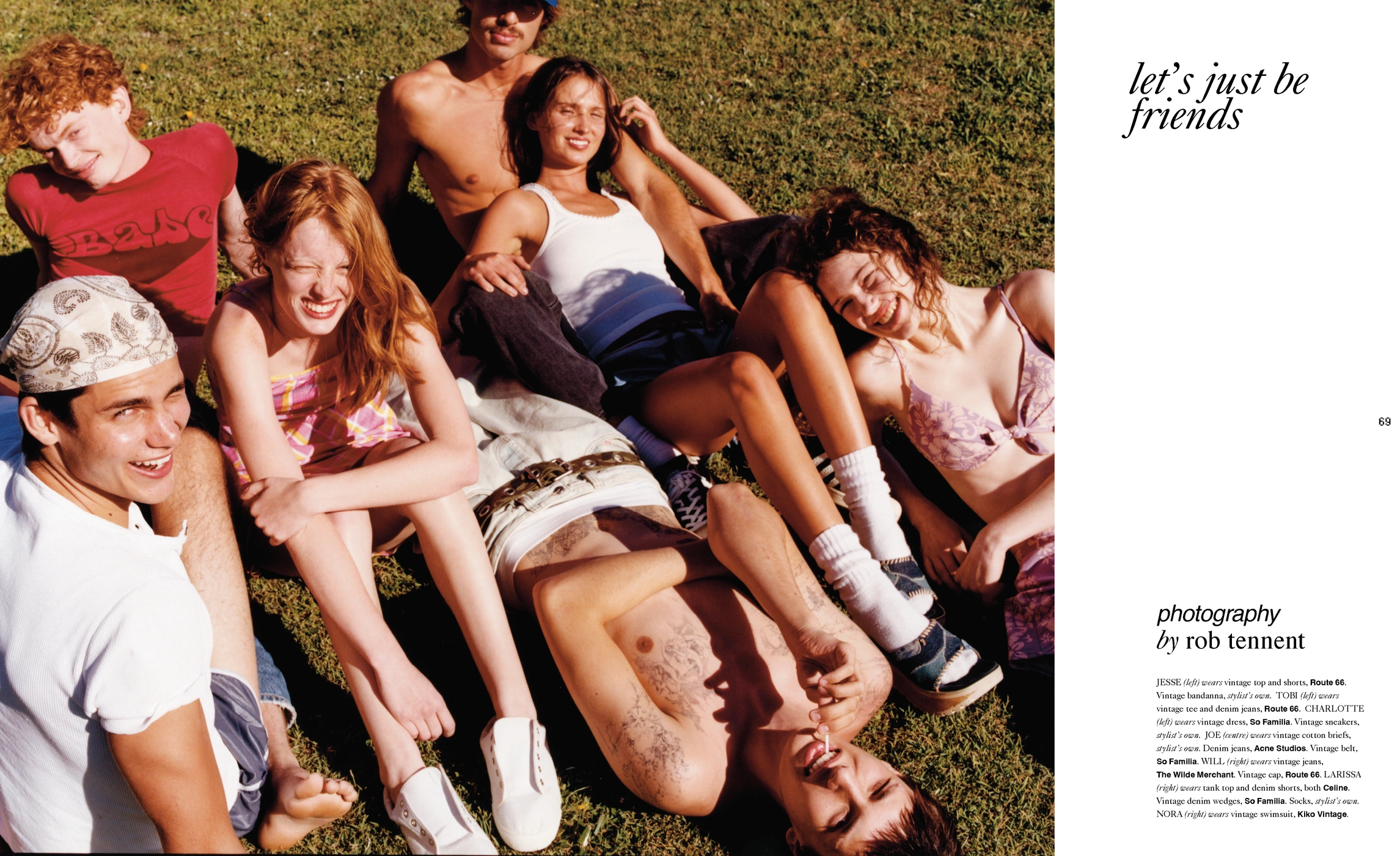 Group of six young people lounging and laughing together on a sunlit lawn outdoors in a candid editorial lifestyle scene.