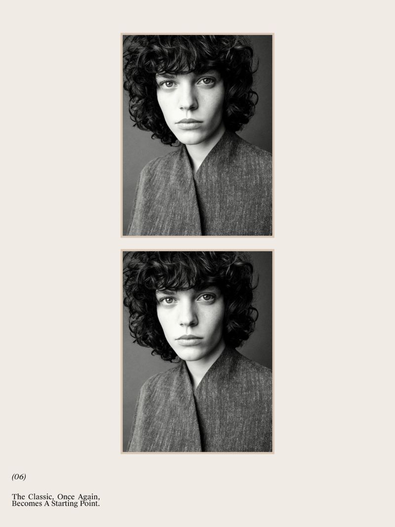 Black and white portrait of a young woman with curly hair and gray top, framed by a cream-colored border on a white background, fashion editorial.