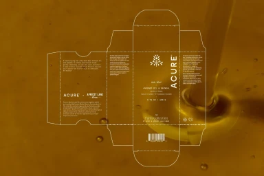 Unfolded flat packaging die-line for Acure soap with white text overlay set against a flowing golden amber liquid.