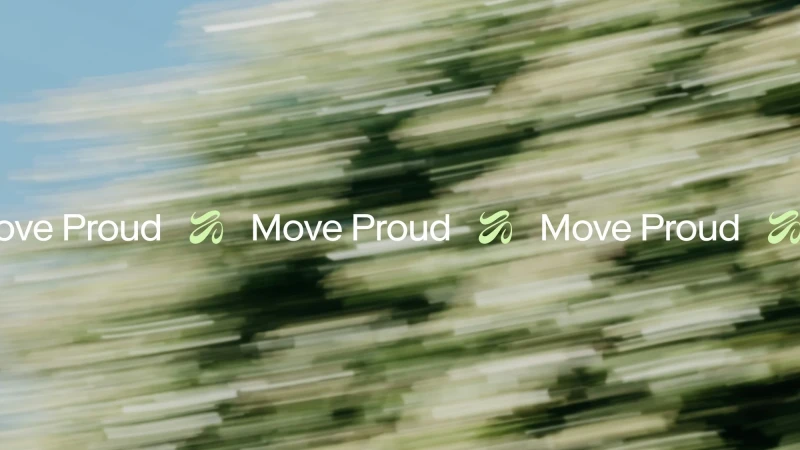 Abstract view of blurred green trees with light blue sky and the white text overlay, 'Move Proud,' for a motion graphic.