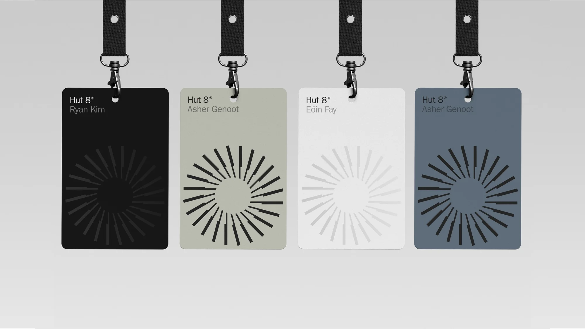 Four colorful name tags hanging with black lanyard straps. The tags feature a circular radiating pattern and the text 'Hut 8'.