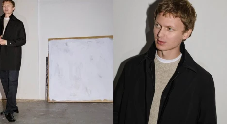 Model Jonas Glöer in a black coat and neutral knitwear against a plain wall for Massimo Dutti Perspectives