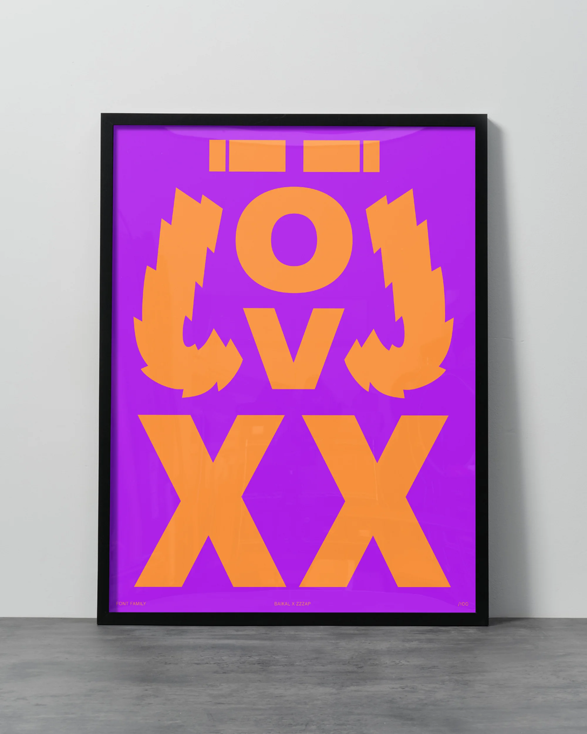 Graphic art print in black frame against white wall: orange abstract text and shapes on purple background, flat lay composition.