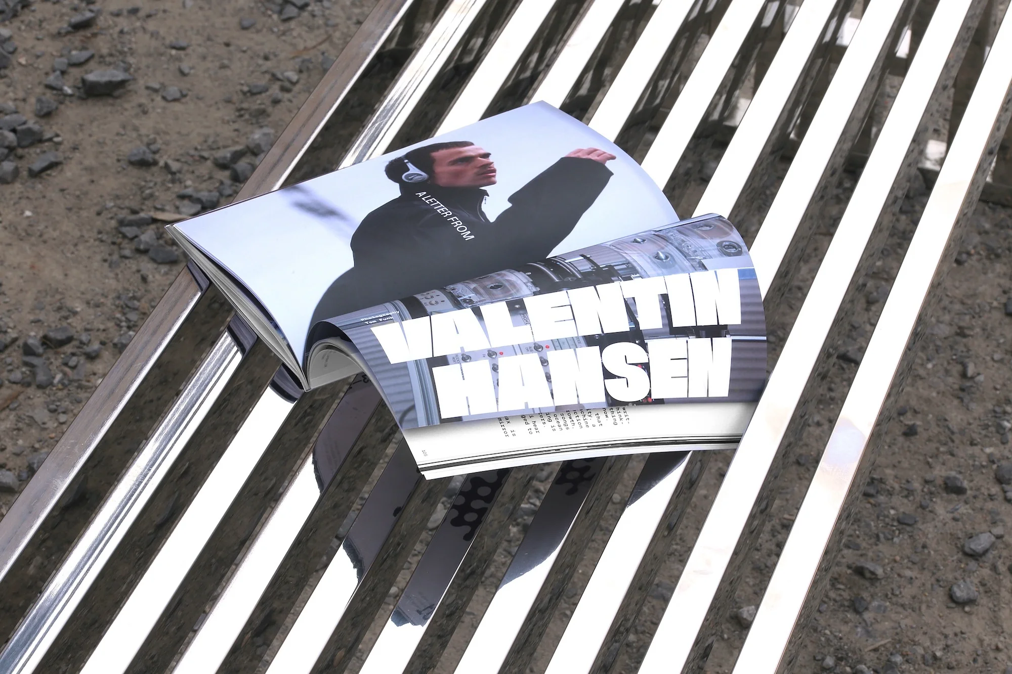 Open magazine on a metal bench features an image of a man in headphones and the name 'Valentin Hansen' in bold white letters.