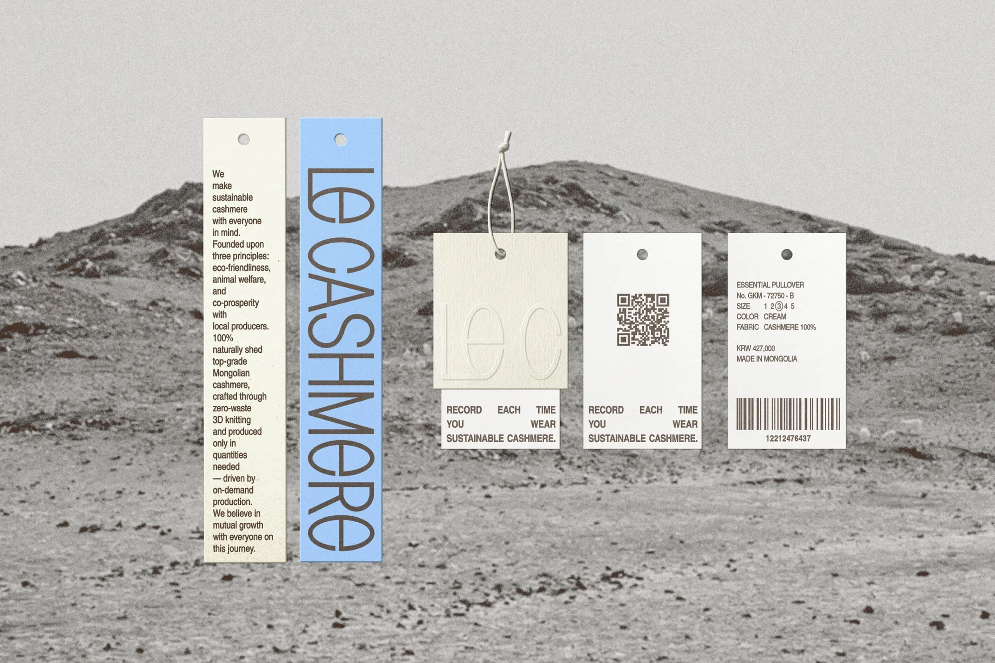 Promotional image showcasing multiple 'Le Cashmere' tags with product details against a desert landscape with a mountain range.