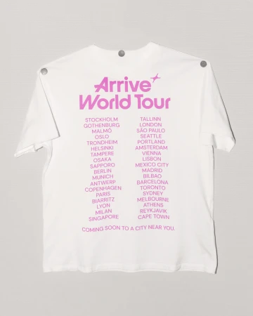 White t-shirt with 'Arrive World Tour' in pink text, listing cities like Stockholm, London, Mexico City, and Cape Town in pink.