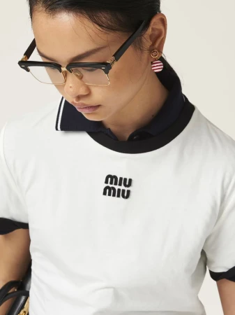 Model wearing black eyeglasses and white t shirt with Miu Miu logo for campaign