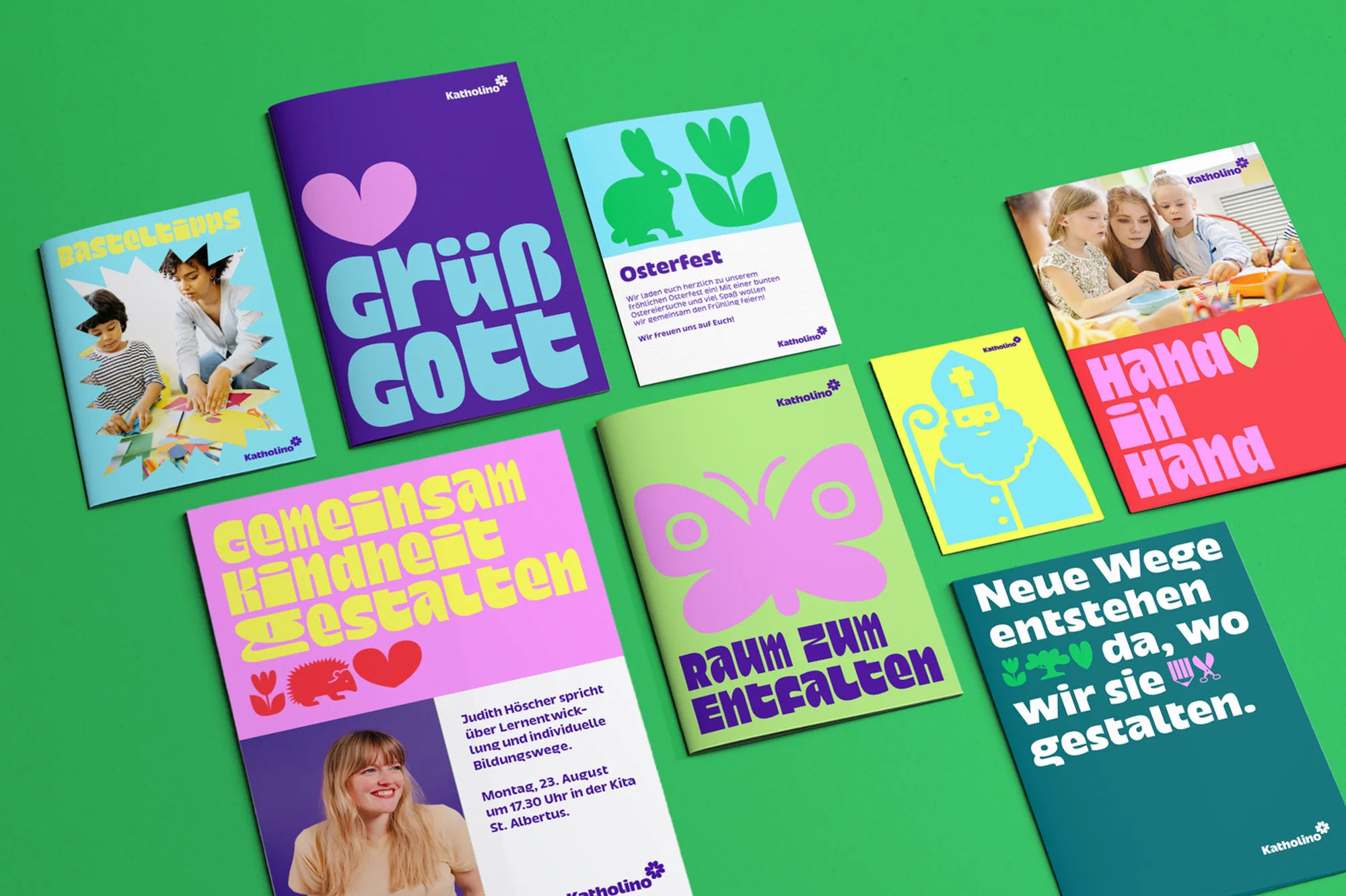 Collection of vibrant promotional brochures arranged on a green surface, featuring colorful graphics, playful typography, and Katholino branding.
