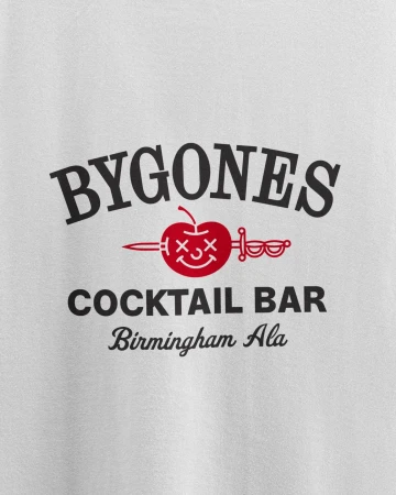T-shirt featuring 'BYGONES COCKTAIL BAR Birmingham Ala' text with an apple pierced by a sword, set against a white background.