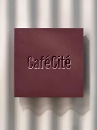 Burgundy square block featuring debossed CafeCite typography set against a corrugated white background with soft shadows