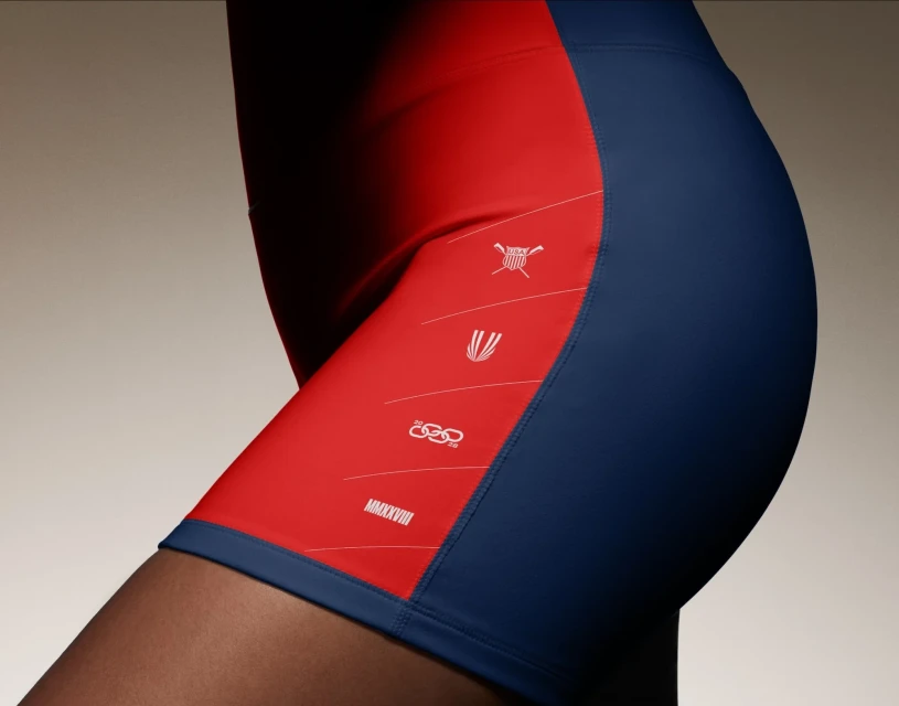 Close-up of person wearing red and blue athletic shorts with graphic designs, emphasizing fitness apparel and activewear fashion.