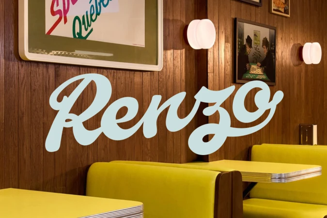 Interior of a diner-style restaurant with yellow booths, wood paneling, wall art, and sconce lighting; logo 'Renzo' in the foreground.
