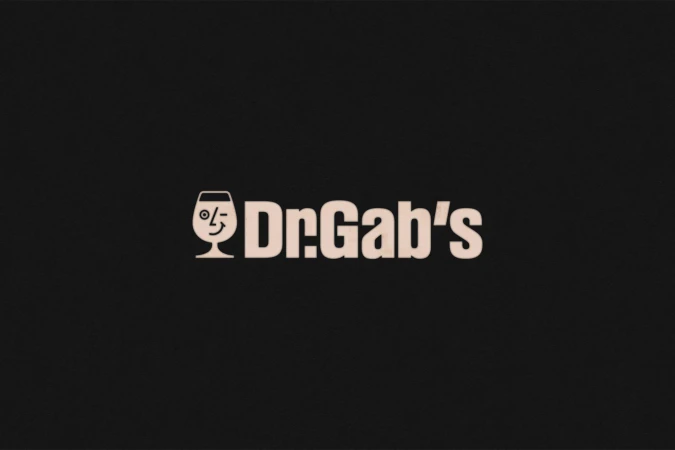 Dr. Gab's logo featuring a wine glass with a winking face on a black background, promoting the brand with a playful and inviting design.