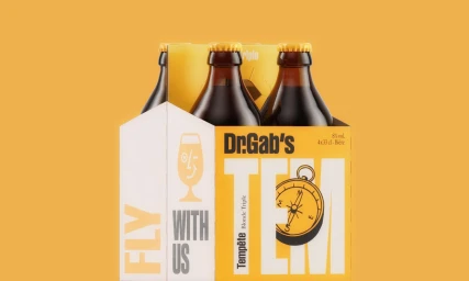 Four-pack of Dr. Gab's beer bottles in a yellow and white cardboard carrier against a warm yellow background.