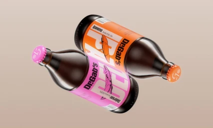 Two amber glass beer bottles with orange and pink labels floating diagonally against a neutral beige background.