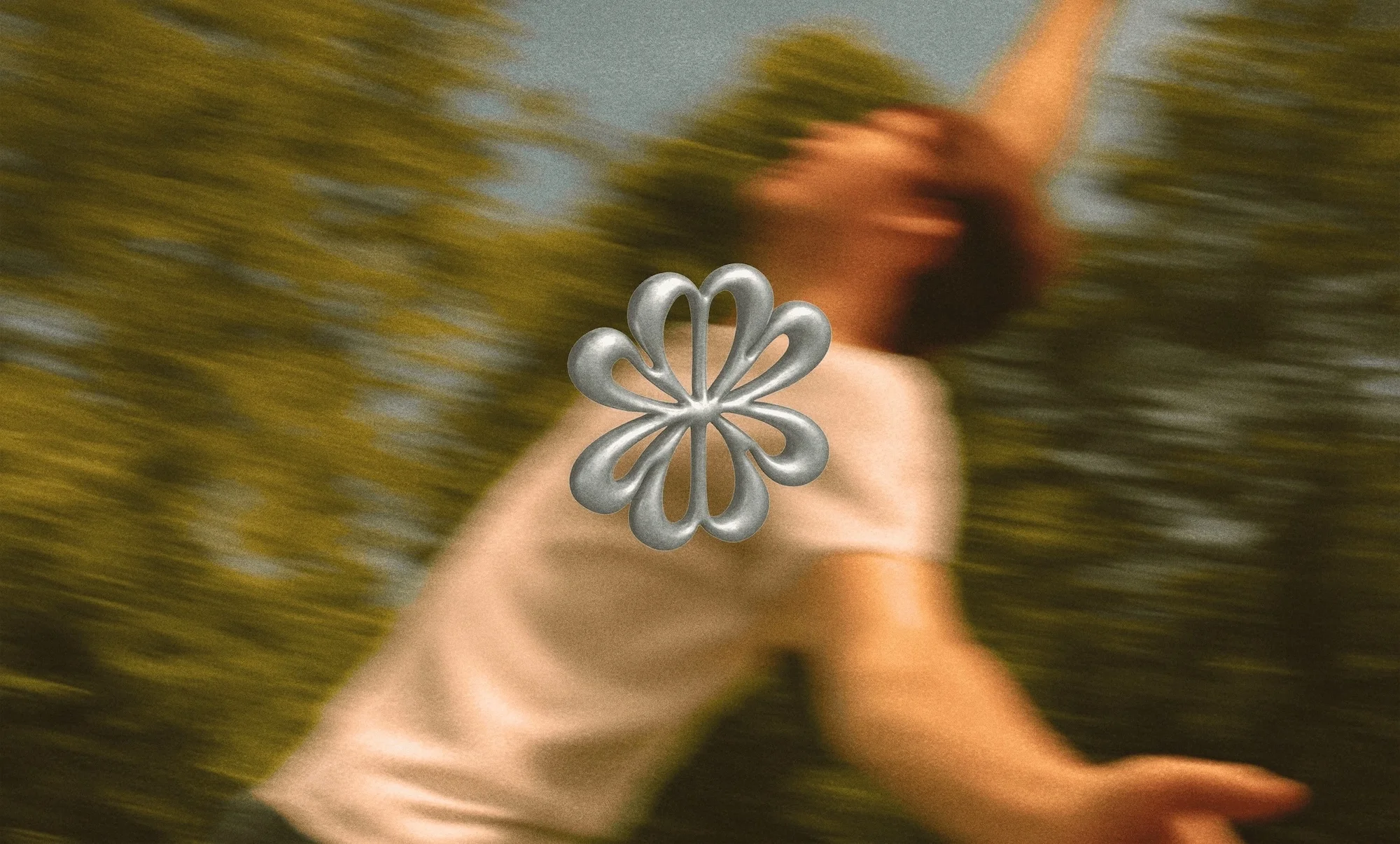 Motion-blurred view of a person outdoors with arm raised, wearing a t-shirt. An abstract floral design is layered in the foreground.