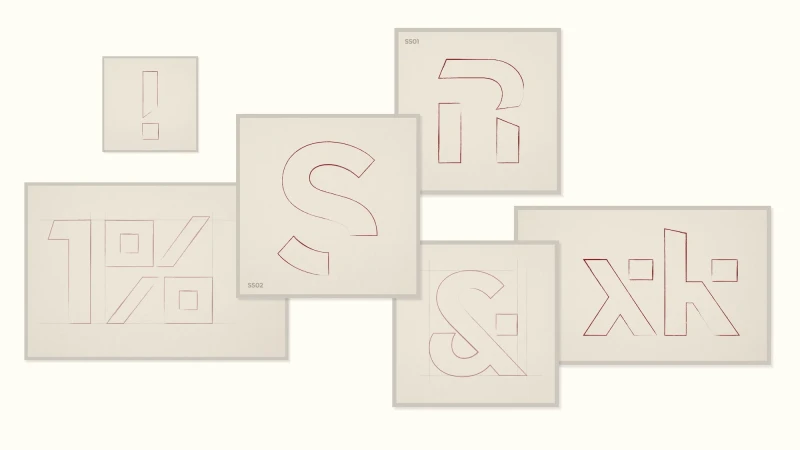 Typography art with red outlined symbols on white paper, creating a modern and minimalist design with geometric shapes and lines.