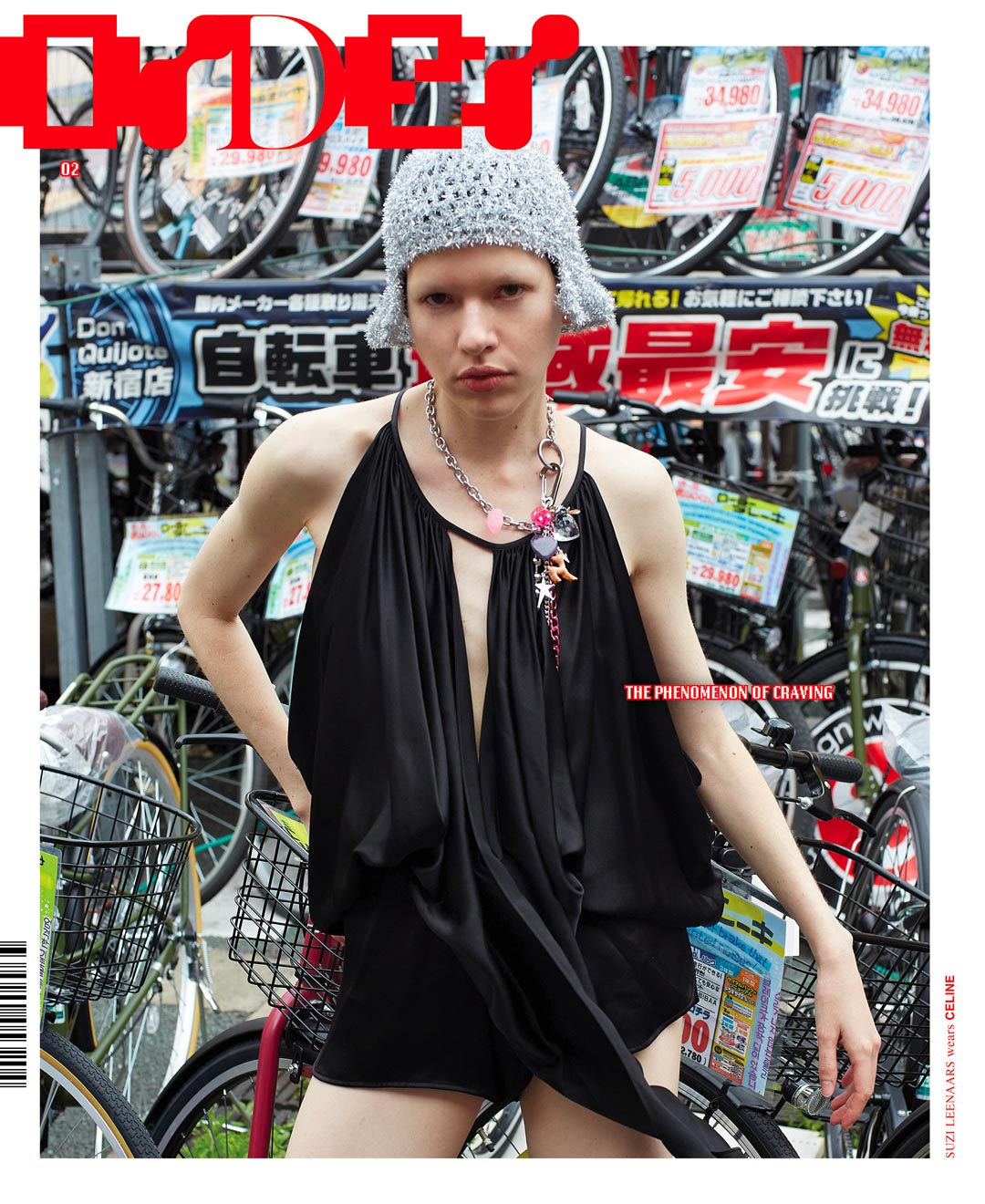Editorial fashion shot of a person with a knit hat and black dress posing in front of bicycles in an outdoor urban setting.