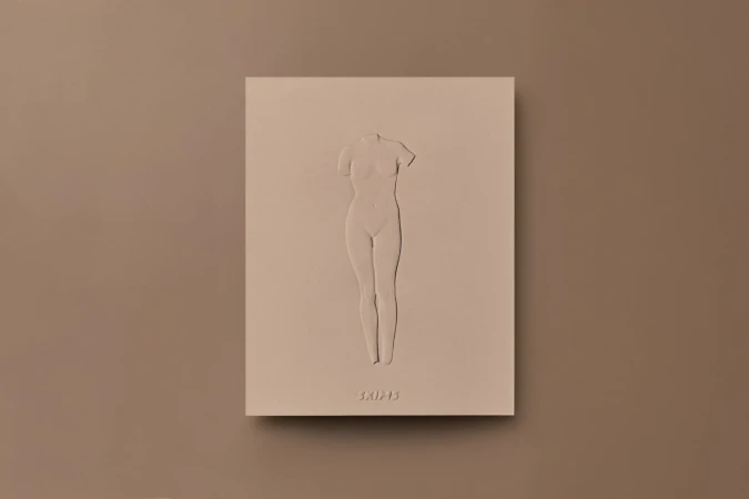 Beige studio shot features a 3D sculpture of a headless female torso mounted on a matching block with minimal surface textures.