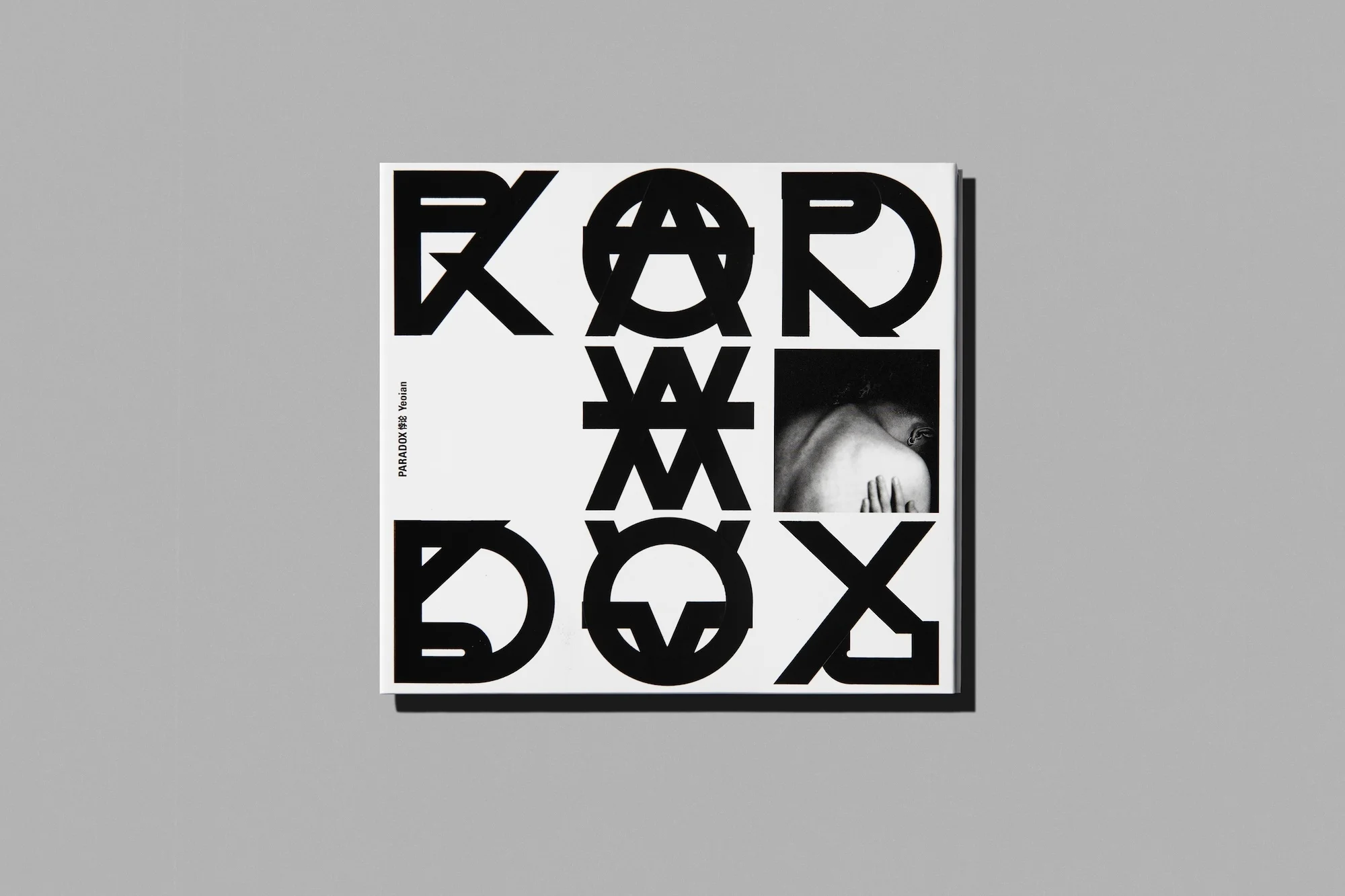 Monochrome image of a PARADOX WE Tension album cover featuring typographic design and a black and white human figure. 