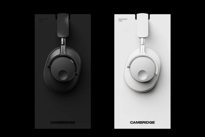 Studio shot of black and white Cambridge Audio Melomania P100 headphones on matching colored boxes. Modern product photography.