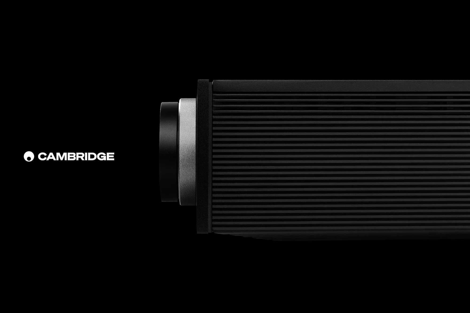 Close-up of a sleek black audio component with silver accents, set against a dark background, highlighting its design and texture.