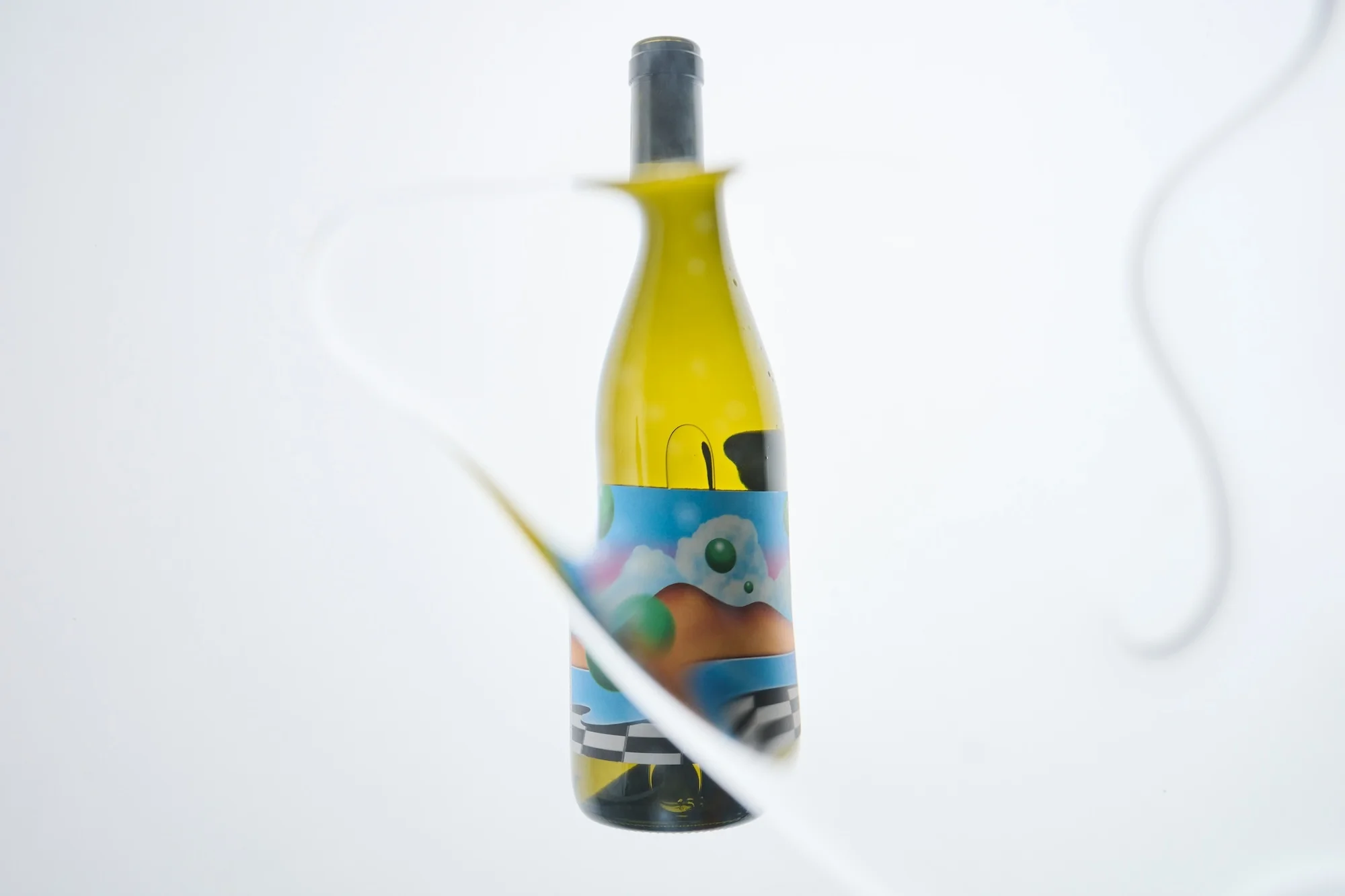 Stylized wine bottle with colorful label and white cable accents on a plain white backdrop. Focus is on label design.