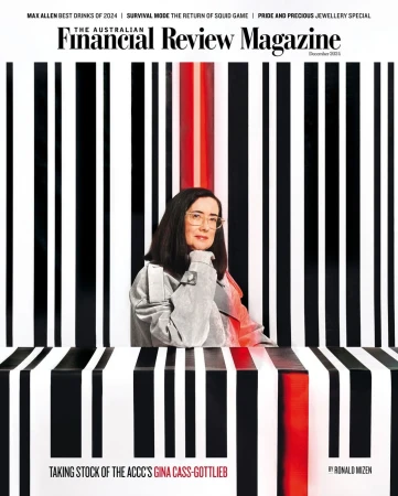 Magazine cover featuring a woman with glasses and a gray jacket, posed against a striped black, white, and red background.