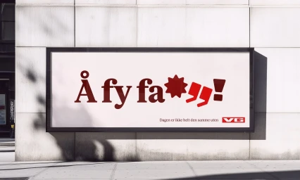 A large outdoor billboard displaying typographic branding on a pale stone wall under natural daylight.
